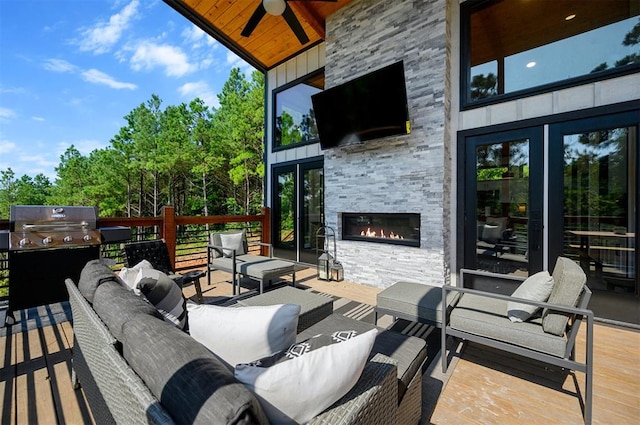 view of patio / terrace with an outdoor living space with a fireplace, grilling area, ceiling fan, and a wooden deck