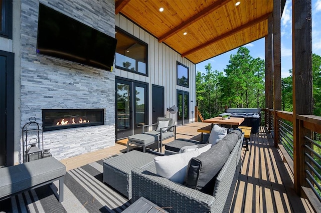 wooden terrace featuring an outdoor stone fireplace