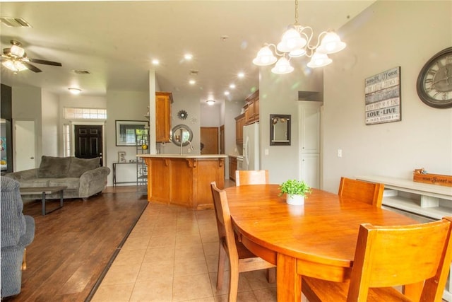 dining space featuring ceiling fan with notable chandelier and light tile patterned floors