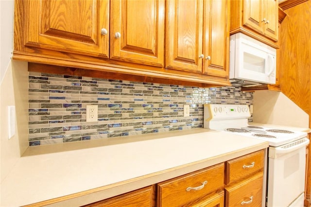 kitchen featuring decorative backsplash and white appliances