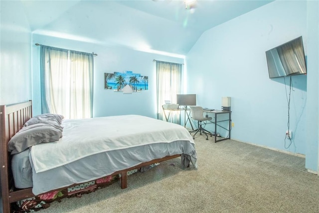 carpeted bedroom featuring lofted ceiling and multiple windows