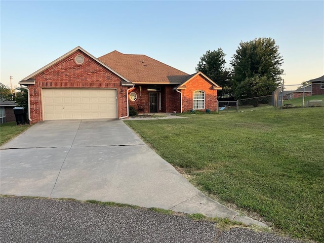 ranch-style home with a yard and a garage