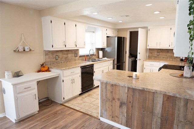 kitchen with dishwasher, white cabinets, sink, stainless steel fridge, and light hardwood / wood-style floors