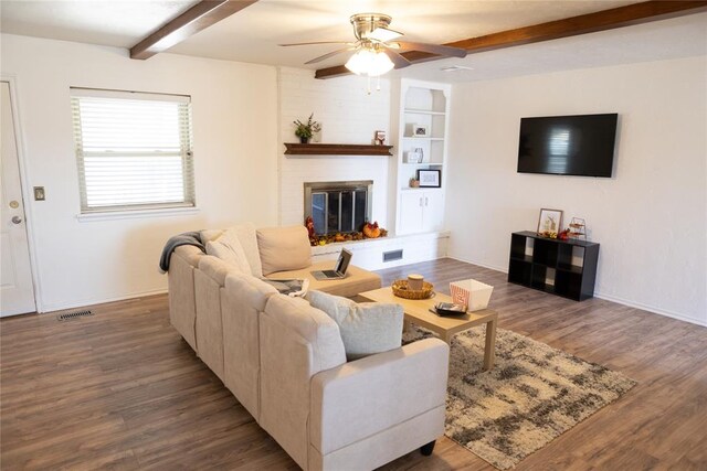 living room featuring hardwood / wood-style floors, ceiling fan, beam ceiling, and a fireplace