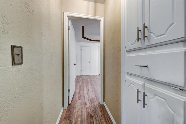 corridor with wood-type flooring