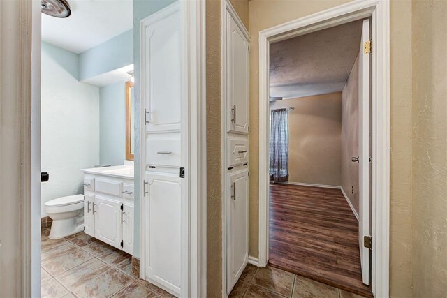 bathroom with hardwood / wood-style floors, vanity, and toilet