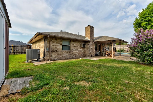 rear view of house with a lawn, a patio area, a wall mounted air conditioner, and central AC unit