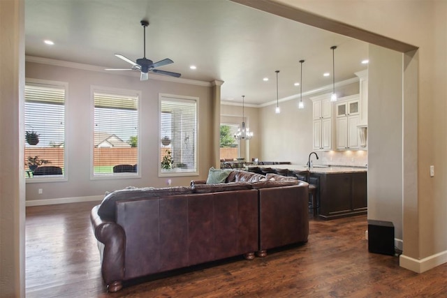 living room with sink, dark hardwood / wood-style flooring, ceiling fan with notable chandelier, and ornamental molding