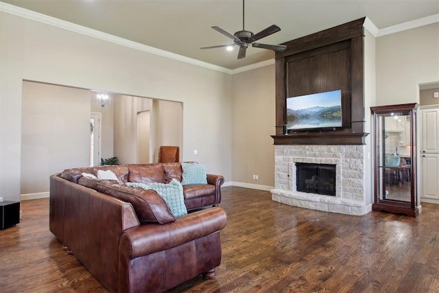 living room featuring a fireplace, dark hardwood / wood-style floors, ceiling fan, and ornamental molding