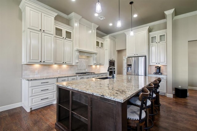 kitchen with white cabinets, a kitchen island with sink, sink, and appliances with stainless steel finishes