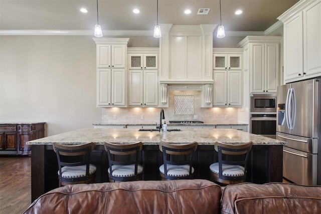 kitchen featuring sink, an island with sink, pendant lighting, and appliances with stainless steel finishes