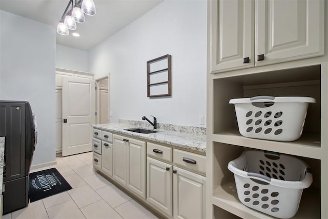 interior space featuring light stone counters, light tile patterned floors, and sink