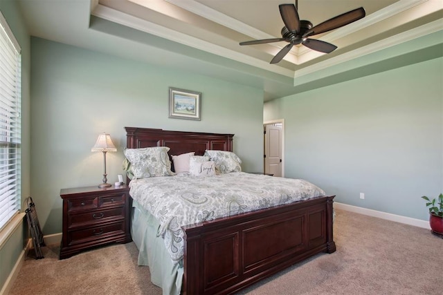 bedroom with a raised ceiling, ceiling fan, light carpet, and ornamental molding