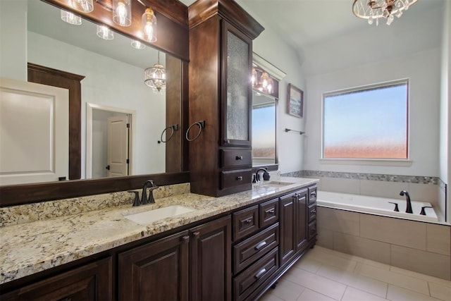 bathroom featuring tile patterned floors, vanity, a relaxing tiled tub, and a chandelier