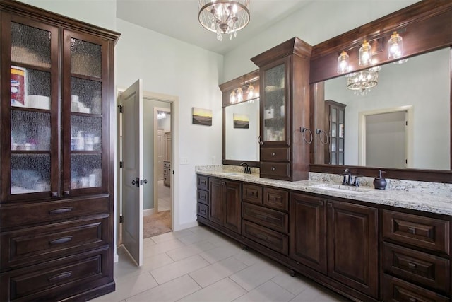 bathroom featuring tile patterned flooring, vanity, and a notable chandelier