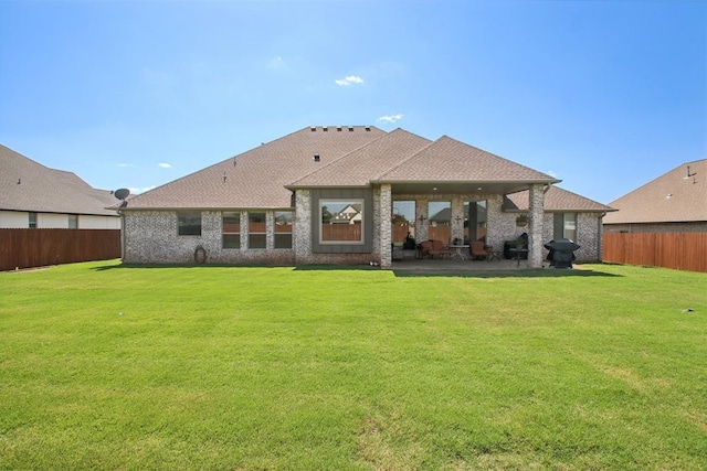 rear view of property with a yard and a patio