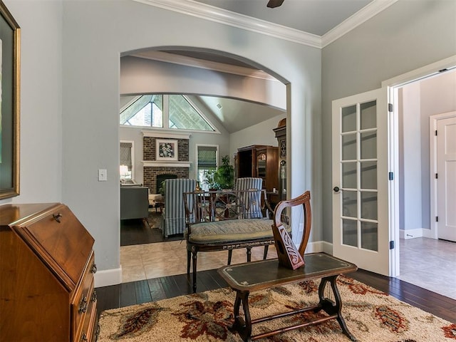 dining space featuring a fireplace, wood-type flooring, vaulted ceiling, and ornamental molding