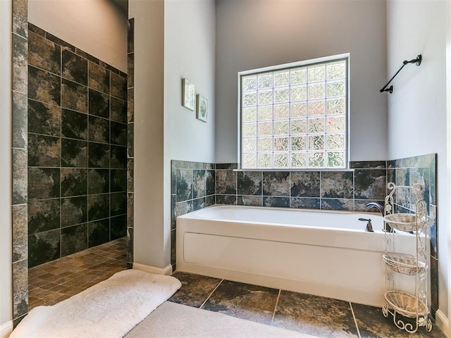 bathroom featuring independent shower and bath