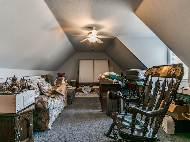 interior space featuring a textured ceiling, ceiling fan, dark carpet, and vaulted ceiling