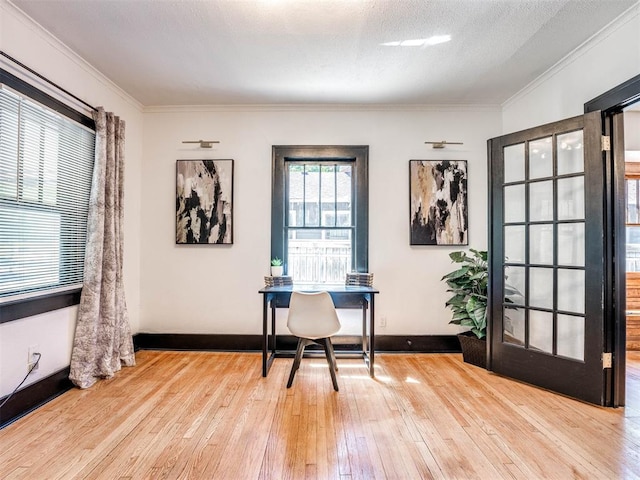 unfurnished office with a textured ceiling, crown molding, and light hardwood / wood-style flooring