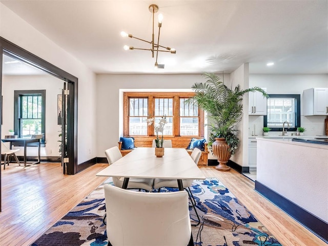 dining room featuring light hardwood / wood-style flooring, a wealth of natural light, and a notable chandelier