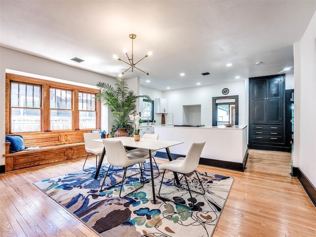 dining area featuring an inviting chandelier and light hardwood / wood-style flooring