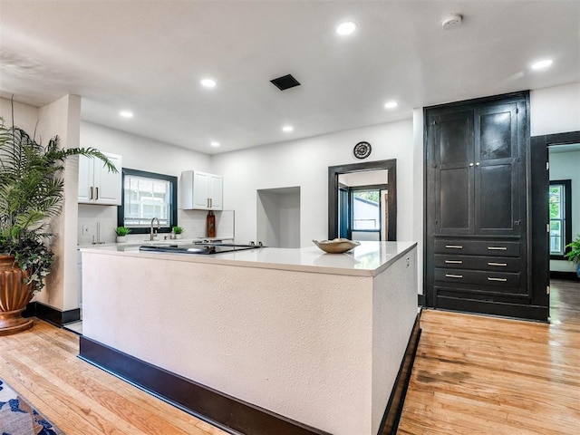 kitchen featuring light hardwood / wood-style flooring, white cabinetry, and a healthy amount of sunlight