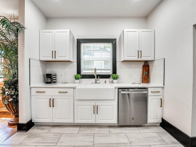 kitchen with backsplash, dishwasher, white cabinetry, and sink