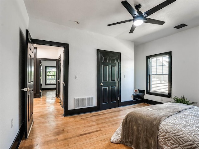 bedroom featuring light hardwood / wood-style floors, multiple windows, and ceiling fan