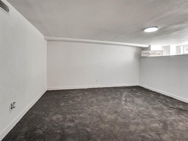 carpeted empty room featuring a textured ceiling