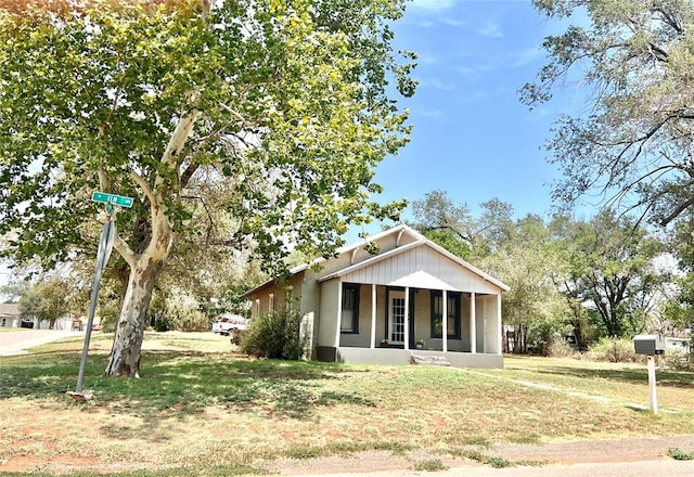 view of front facade with covered porch and a front yard