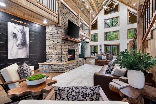 living room featuring hardwood / wood-style flooring, wood walls, a fireplace, and high vaulted ceiling