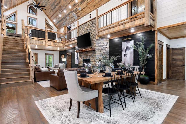 dining space featuring wooden ceiling, a fireplace, high vaulted ceiling, and wood-type flooring