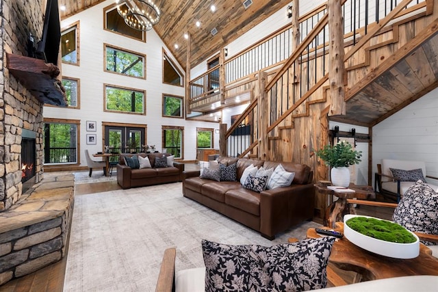 living room featuring wooden walls, a barn door, high vaulted ceiling, wooden ceiling, and a notable chandelier