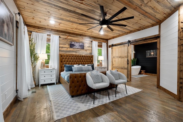 bedroom featuring wood ceiling, ceiling fan, a barn door, dark hardwood / wood-style floors, and wood walls