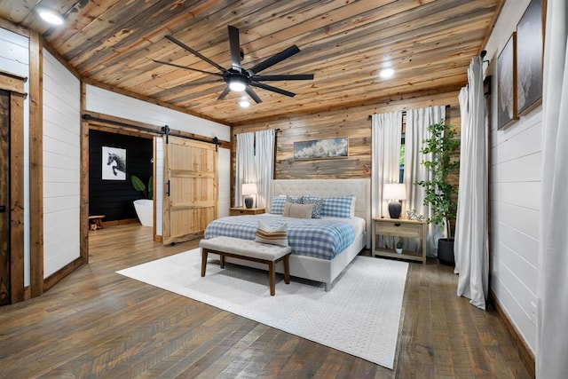 bedroom with wood walls, wooden ceiling, ceiling fan, a barn door, and dark hardwood / wood-style floors