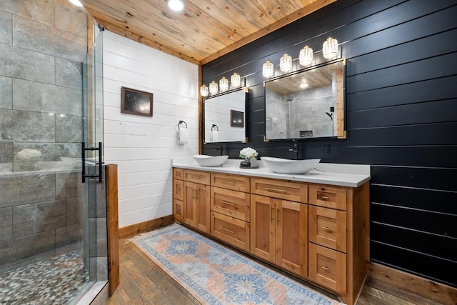 bathroom featuring wooden walls, vanity, wooden ceiling, and a shower with shower door