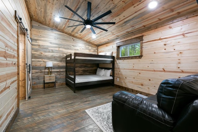 bedroom featuring wood walls, lofted ceiling, wooden ceiling, dark hardwood / wood-style floors, and a barn door