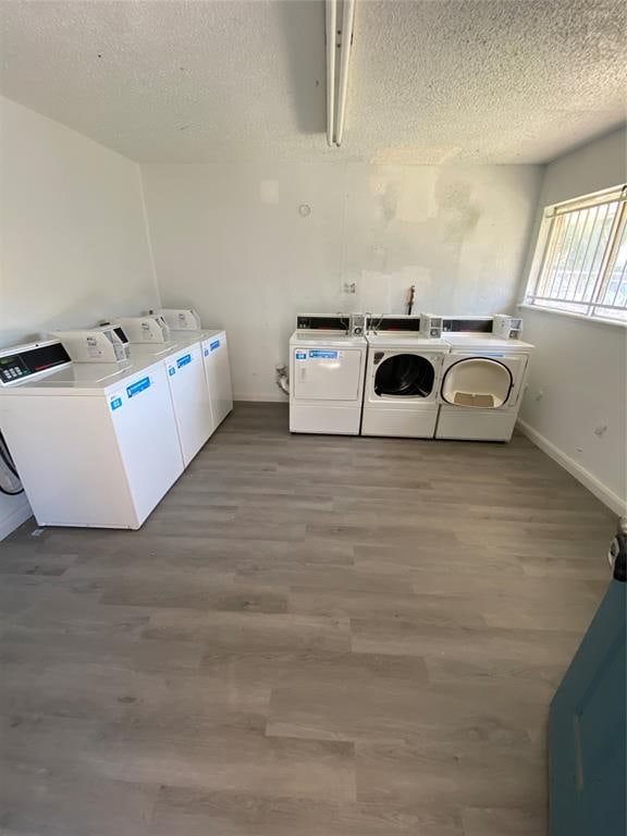 washroom with washer and dryer, hardwood / wood-style floors, and a textured ceiling