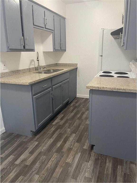 kitchen with gray cabinetry, refrigerator, dark wood-type flooring, and sink