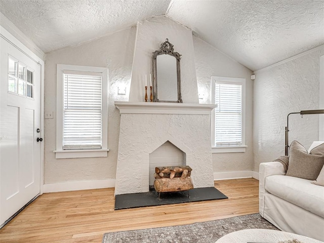 living room with hardwood / wood-style floors, lofted ceiling, and a textured ceiling