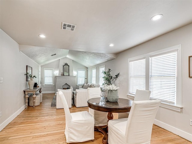 dining space featuring lofted ceiling and light wood-type flooring