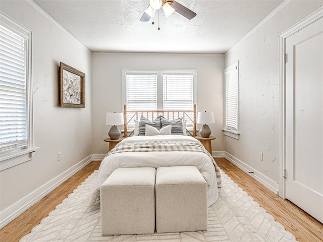 bedroom with ceiling fan, light hardwood / wood-style flooring, and a textured ceiling