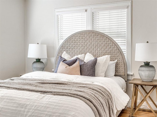 bedroom with hardwood / wood-style floors and multiple windows