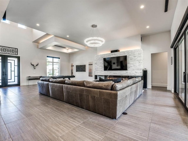 living room with a stone fireplace and an inviting chandelier