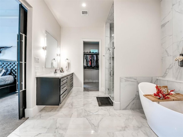 bathroom featuring vanity, separate shower and tub, and tile walls