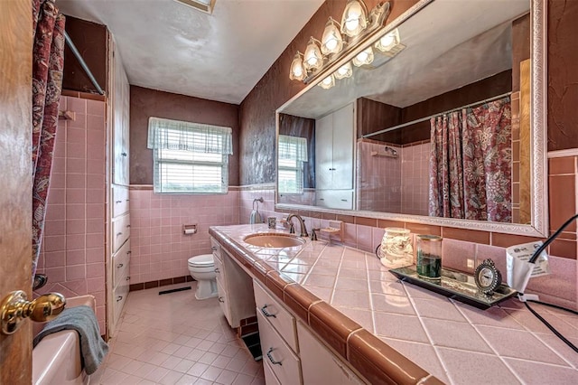 full bathroom with vanity, tile patterned flooring, toilet, tile walls, and shower / tub combo with curtain