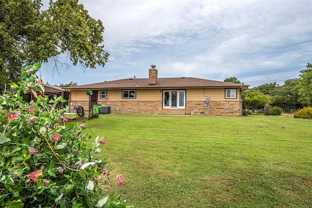 back of house featuring a yard and central AC