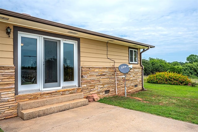 view of side of home with a patio area and a yard