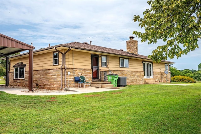 back of property with a yard and central AC unit